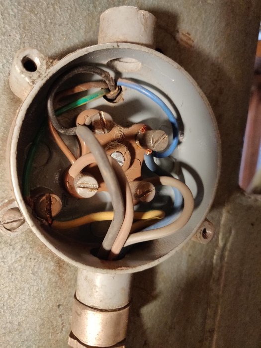 Gamla däckmaskinens öppna kopplingsdosa med flera kablar och lösa kopplingar.