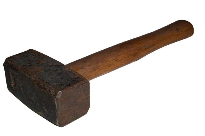 Slägga med trähandtag och slitna svartfärgade metallhuvud mot vit bakgrund.