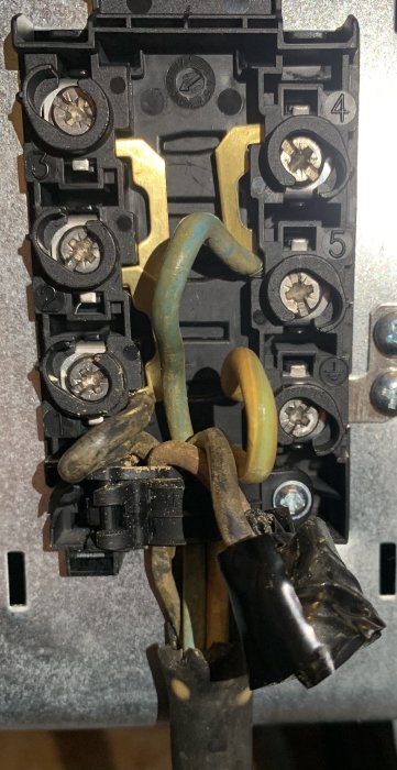 Bränt eluttag med svart, blå och gulgrön kabel synlig, möjlig felkoppling nämnt i diskussionstråd.