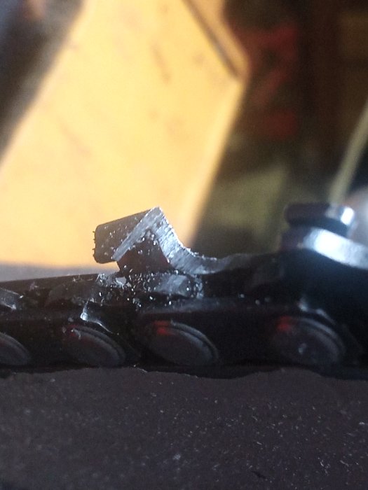 Närbild av en nyfilad skärtand på en motorsågskedja från Biltema.