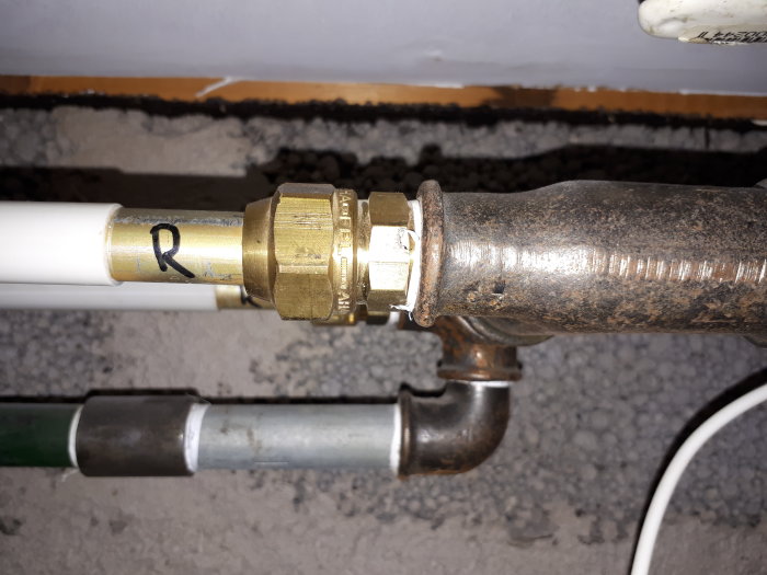 Radiatoranslutning med 15mm prisolrör och mässingskoppling mot ett äldre rör.