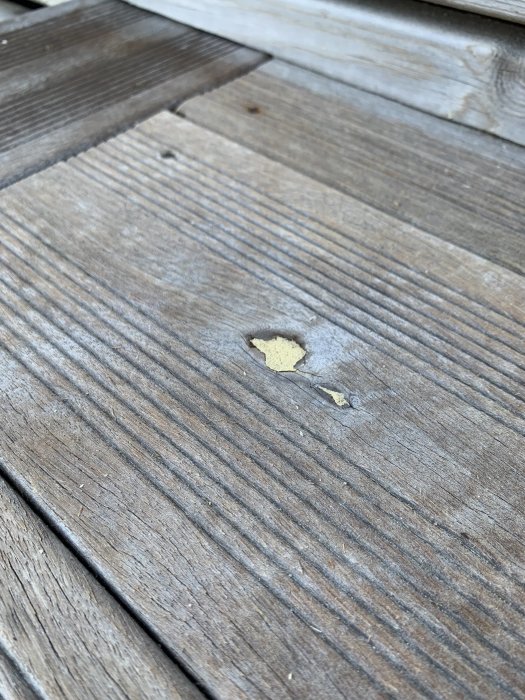 Skadat område på trätrall med flagande material.
