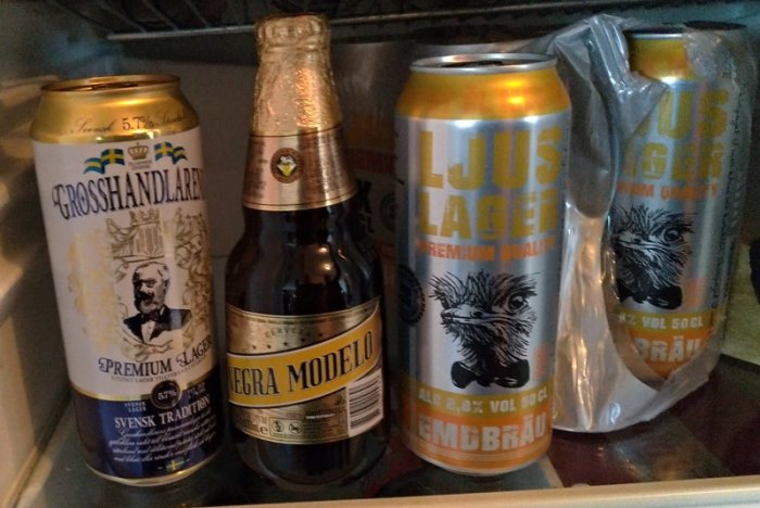 Fyra olika ölburkar och flaskor i ett kylskåp, inklusive Grosshandlare Lager och Negra Modelo.