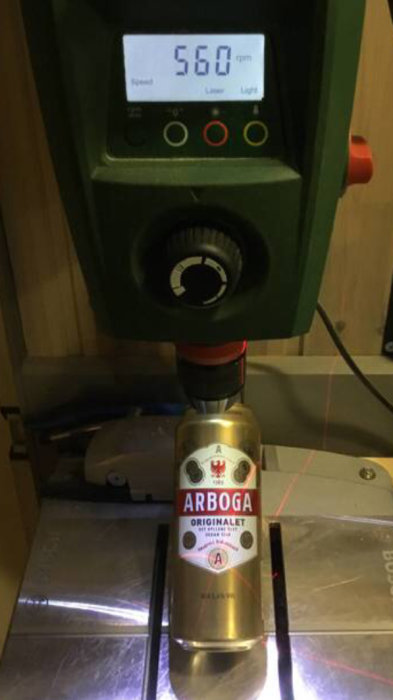 En burk Arboga öl på en borrmaskinsbas under en fuktmätare som visar 56.0 %, skämtsamt jämförd med teknik och dryck.