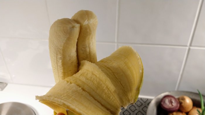 En skrälld tvillingbanan med två sammanvuxna bananhalvor i en hand.