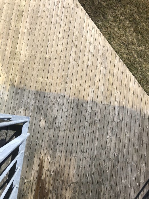 Renoverad trädäck halvvägs rengjord visar skillnad mellan smutsiga och rena ytor.