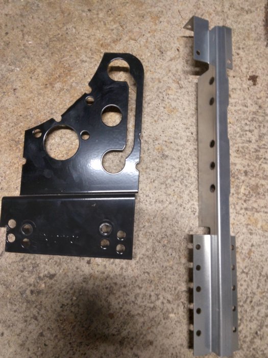 Svarta snörasskyddsfästen för betongpannor på ett grått underlag.