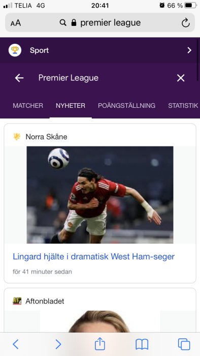 Fotbollsspelare i Manchester United-tröja nickar bollen under en match.