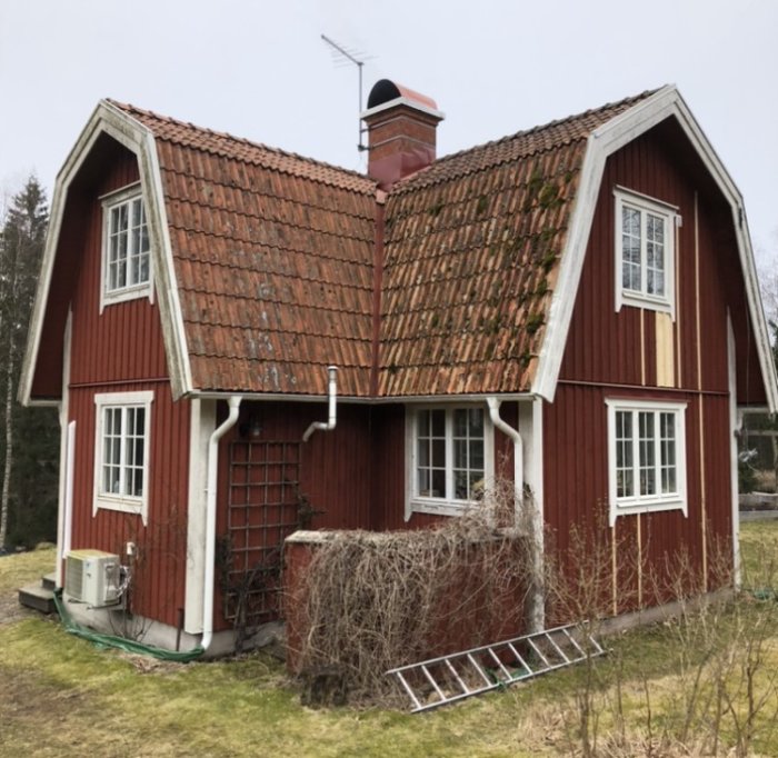 Rött torp med två våningar och mossbeklätt tak, där utbyggnad för badrum planeras.