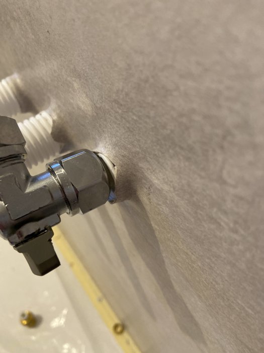 Vägg i badrum med väggbricka och rörinstallation som ej följer angivna mått från Säker Vatten-standard.