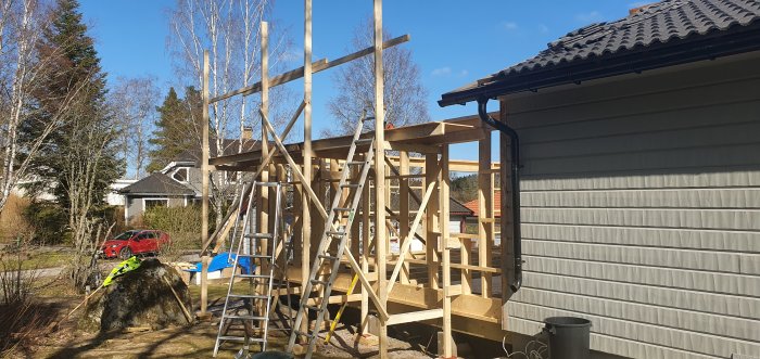 Byggnadsställning och reglar monterade vid en bostadsrenovering i soligt väder.