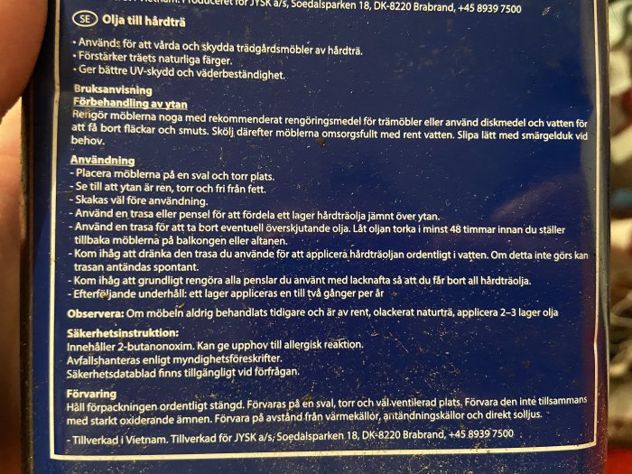 En närbild av instruktioner på baksidan av en burk med möbelolja, instruktionerna beskriver användning och säkerhetsinformation.