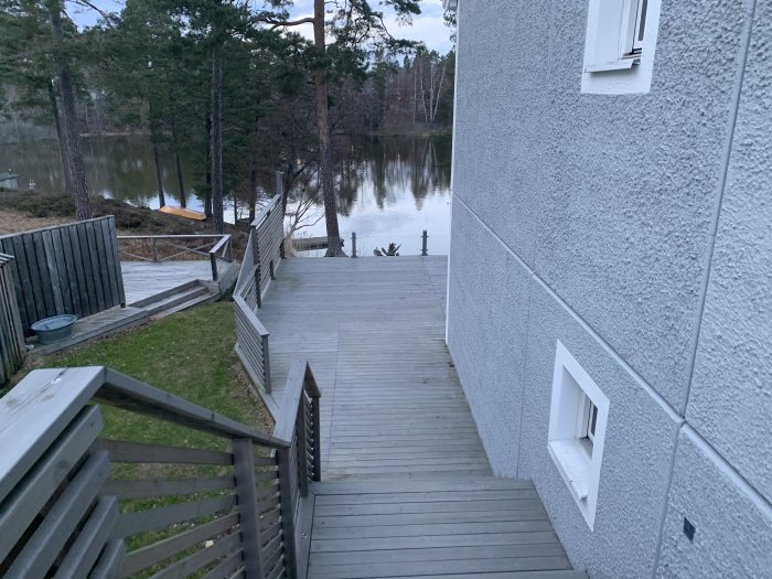 Altan renoverad med grå lasyr, med trappa och utsikt över en sjö bakom huset.