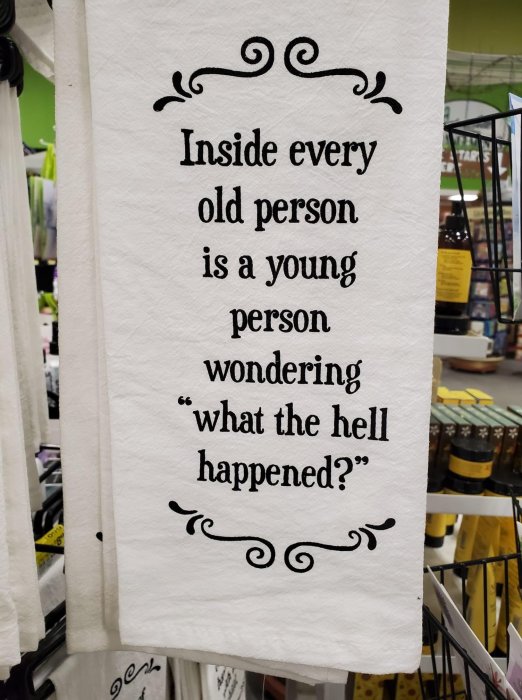 Text på en kökshandduk med citatet "Inside every old person is a young person wondering what the hell happened?