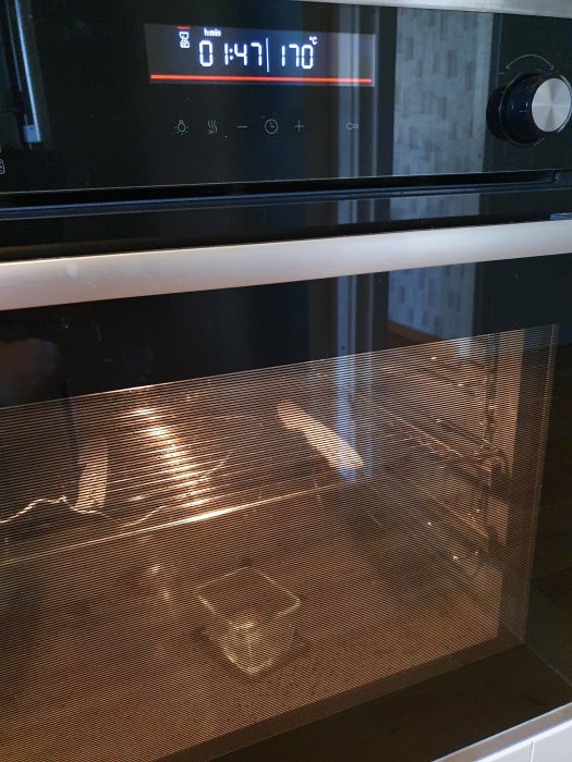 Ugn inställd på 170 grader med en timer som visar 14:41 kvar, och en glasform inuti.