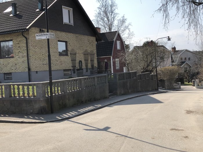 Betongstaket från 60-talet med slitna stolpar och pelare framför ett gult tegelhus, med behov av renovering.