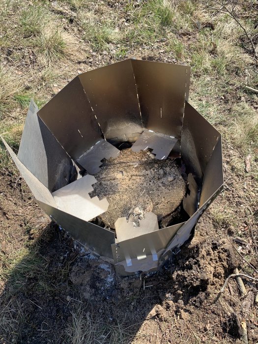 Stor trädstubbe omgiven av metallplåtar för att förbereda rötning eller borttagning.