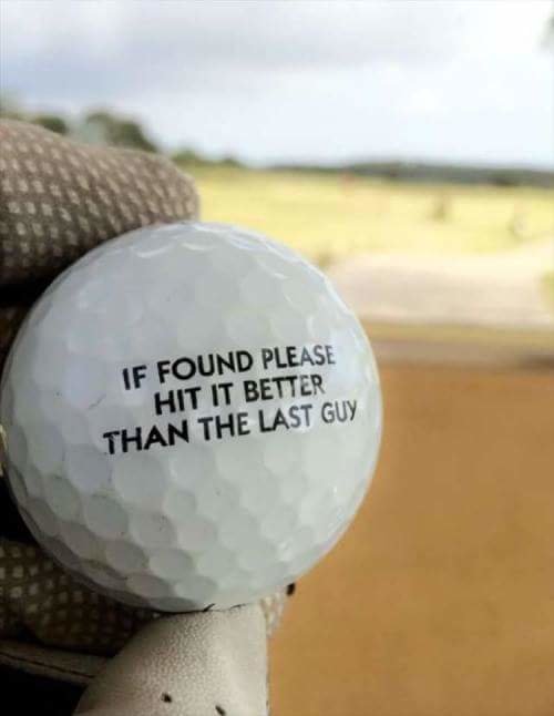 Golfboll med texten "IF FOUND PLEASE HIT IT BETTER THAN THE LAST GUY" mot en golfbana i bakgrunden.