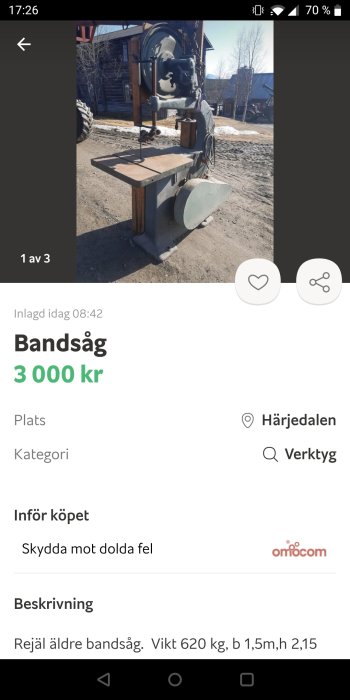 Gammal bandsåg utställd utomhus med teknisk specifikation på skärmen.