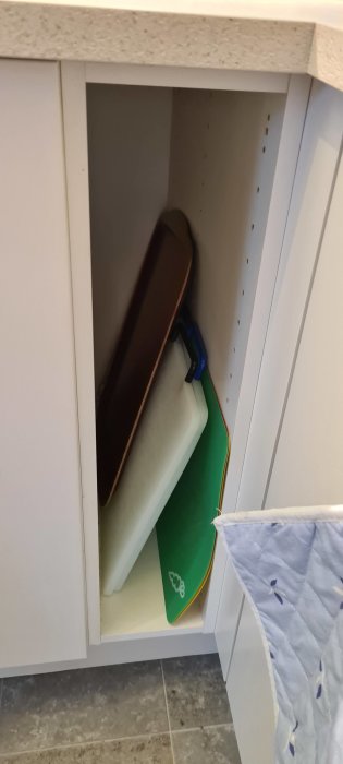 Köksbänk med öppet skåp som visar en elsladd, en bottenplatta samt hål för installation av LED-belysning.