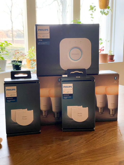 Philips Hue-produkter på en bordsskiva inne, inklusive brygga och smarta ljuskällor.