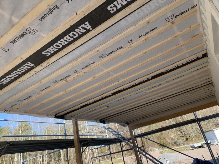 Takstolar i carport med påbörjad installation av ångbroms och isolering.