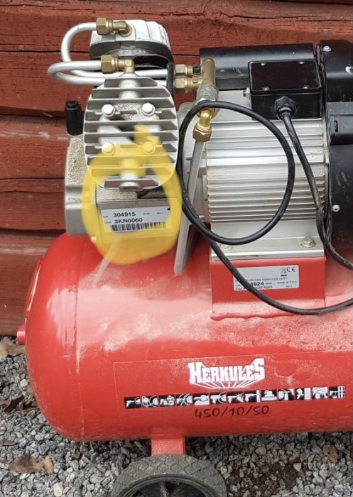 Röd Herkules kompressor utan synligt luftfilter på sidan av cylindrarna.