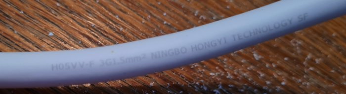 Närbild på en elektrisk kabel med texten "H05VV-F 3G1.5mm² NINGBO HONGYI TECHNOLOGY SF".