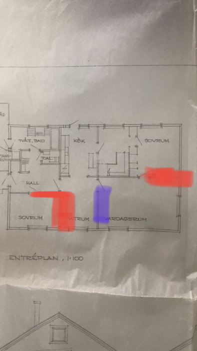 Ritning av bostadsplan med markerade borttagna väggar i rött och en vägg med öppning i blått.