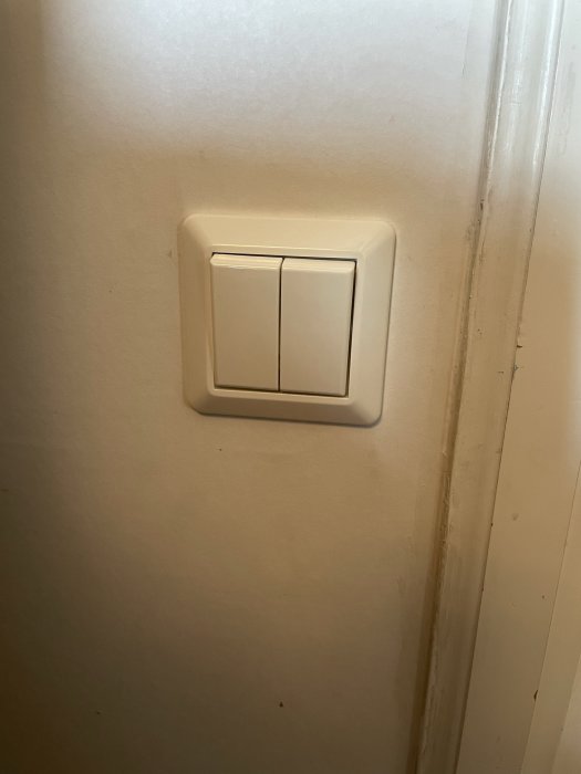 Philips Hue Wall Switch med dubbelknapp installerad på en vägg.