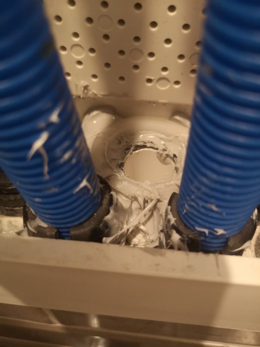 Blåa rör genomföringar med vit avlagring eller rester från byggmaterial runt hålet för svallerröret.
