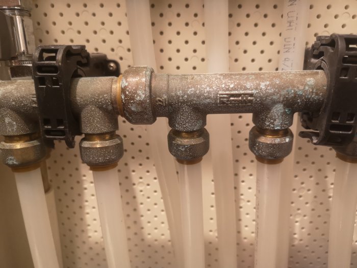 Avlagringar på kopparledningar och fästen med svallerrör 3cm från bottnen på en väggmonterad installation.