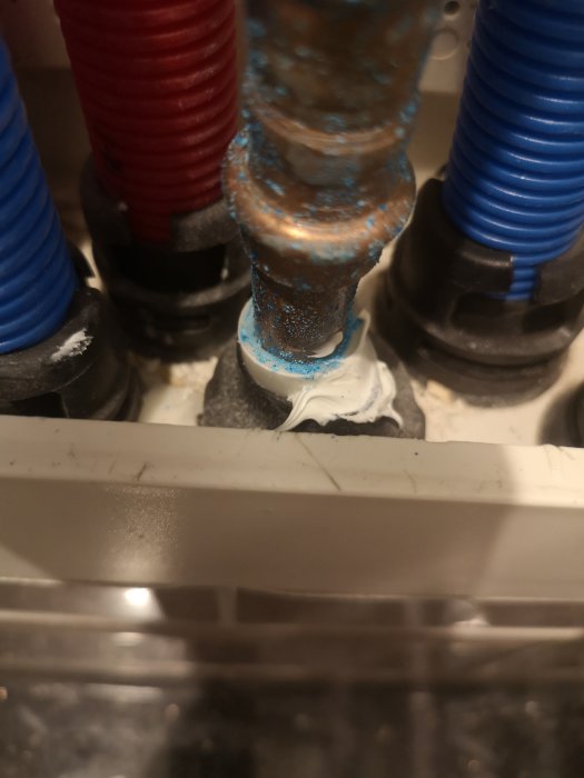 Närbild på rör med avlagringar och ett svallerrör 3 cm från botten i en box.