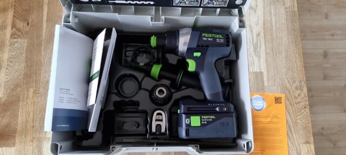 Festool TDC 18/4 sladdlös borrskruvdragare i en öppen låda tillsammans med batteri, laddare och manualer.