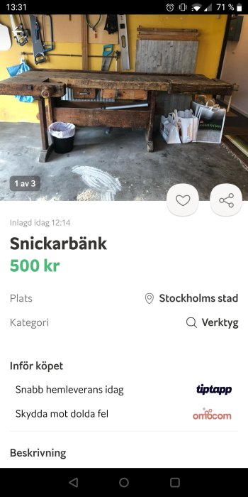 Använd begagnad snickarbänk i trä med verktyg hängande på en vägg i bakgrunden.