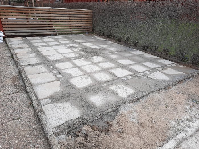 Nybyggd stenlagd yta med 70 betongplattor för cykelparkering vid en uppfart.