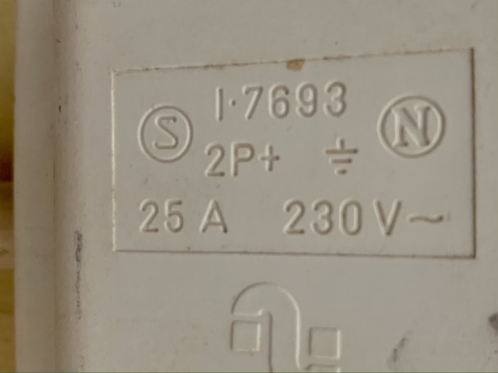 Etikett på vägg med elektriska specifikationer: 25A, 230V, 2P+ jord.