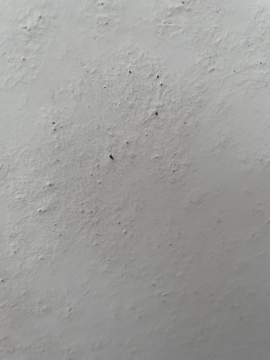 Närbild på en balkongdörrs yta med märken och repor som kan vara skadad färg eller slitage.