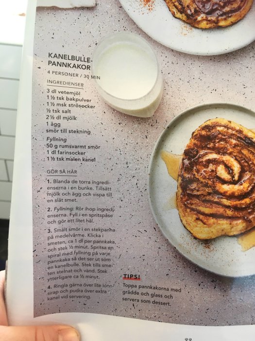 Recept på kanelbullepannkakor från en tidskrift med ingredienser och tillagningsinstruktioner samt färdiga pannkakor på tallrikar.