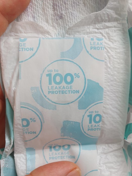 En närbild av en tryckt text på vit bakgrund som lovar "upp till 100% skydd mot läckage".