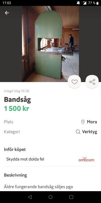 Äldre grönmålad bandsåg i arbetsmiljö med en person i bakgrunden, till salu för 1500 kr i Mora.