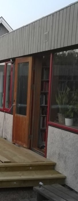 Husfasad med platt tak och en hög grå kant runt taket där ekorrar har sitt revir.