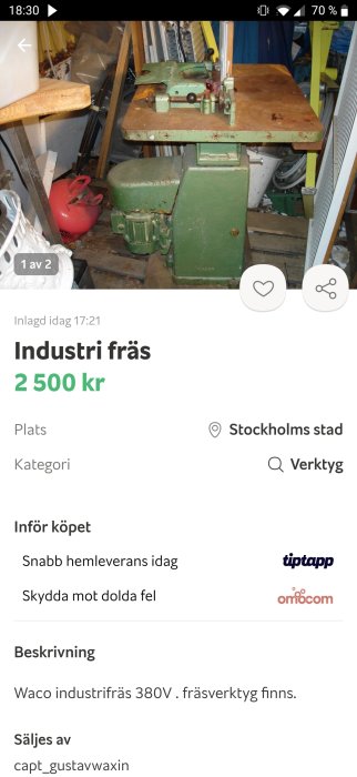 Begagnad industriell fräsmaskin i grönt till salu, placerad i ett rörigt förråd, med annons på en digital marknadsplats.