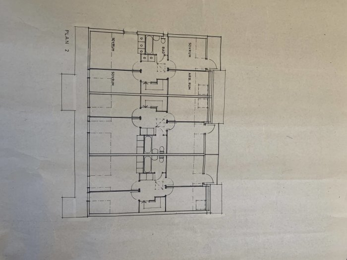 Ritning över planlösning för radhus från 1976, visar rumsuppdelning och möblering.