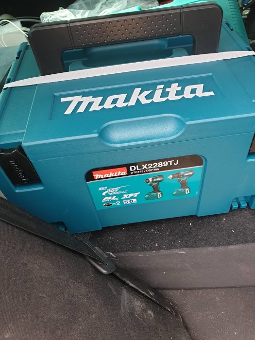 Makita-verktygslåda för DLX2289TJ med bild på borrmaskin och slagdrivare på bilens bakstol.