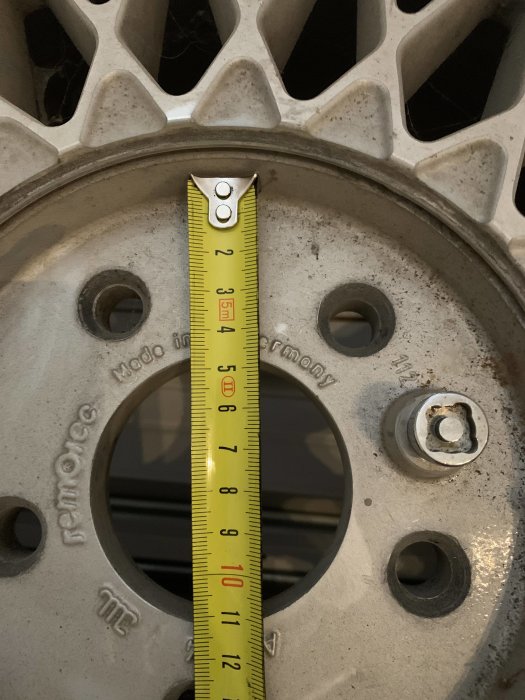 Måttband visar dimensioner på en Remotec-fälg, med fokus på fälgens nav och bultmönster.