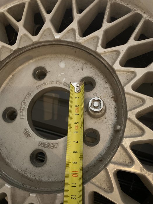 Ett måttband visar storleken på centrumhålet i en grå Remotec-fälg.