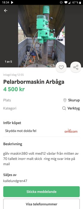 Grön pelarborrmaskin av märket Arboga till salu, placerad i ett garage med diverse verktyg.