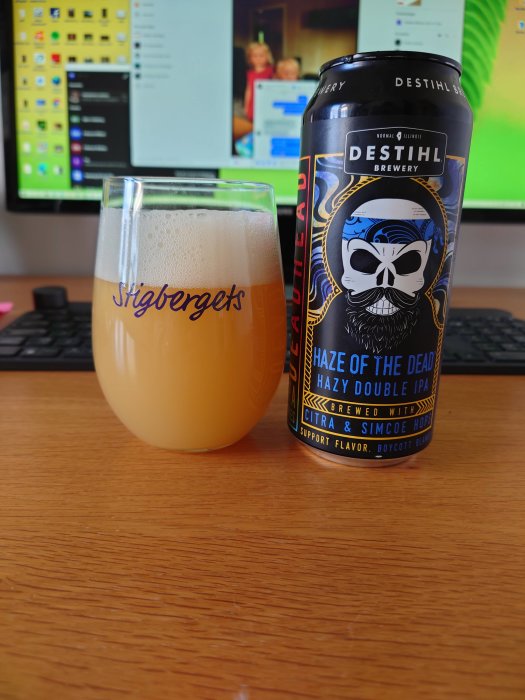 Ölglas märkt "Stigbergets" fyllt med en hazy ale, och en burk "Destihl Haze of the Dead Hazy Double IPA" på ett bord.