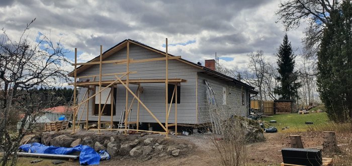 Hus under renovering med nyligen färdigställd gavelspets och byggnadsställningar runtomkring.